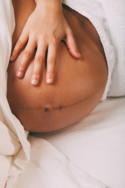 Massage prénatal doux réalisé sur une femme enceinte installée sur le côté